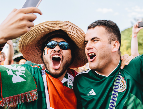 Two men with Mexico's t-shirt celebrating football